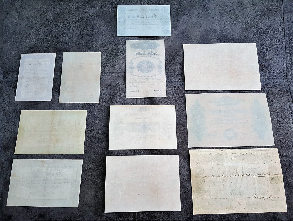 Reverse blank backing view of early Austrian Empire uniface banknotes from 1813 and 1825. Highlights the traditional handmade security rag paper textures, visible plate line indentations, and authentic historical document aging characteristics.